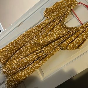 Mustard yellow polka dot knee length dress with tassels.